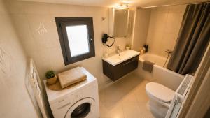 a bathroom with a washing machine and a sink at Alia Beachfront Penthouse with Sea View in Lefkandi Chalkidas +15 photos
