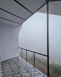 an empty room with a balcony with a view at The Canvo Vattavada Private Cottages in Vattavada +7 photos