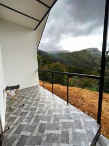 a balcony with a view of the mountains at The Canvo Vattavada Private Cottages in Vattavada