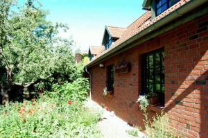 a brick building with a window and a garden at Ferienwohnungen Meyer in Bollewick