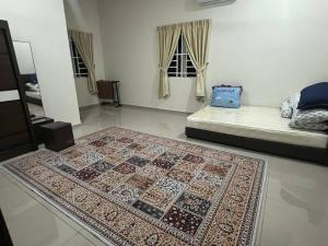 a room with a rug on the floor and a bed at Homestay Abah in Bidur