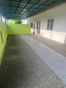an empty hallway of a building with a green wall at Homestay Abah in Bidur