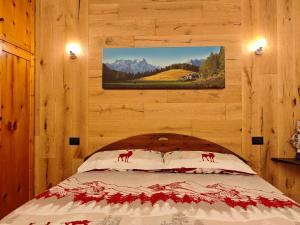 a bedroom with a bed with a painting on the wall at Il Nido al Noce in Morgex