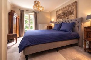 a bedroom with a large bed with a blue comforter at Het Hemelsveld in Hasselt