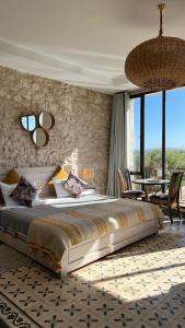 a bedroom with a large bed and a table and chairs at Villa Mamma Giò in Essaouira