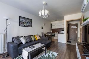 a living room with a couch and a table at Six Corners Garden Corner with Terrace and Parking in Pécs