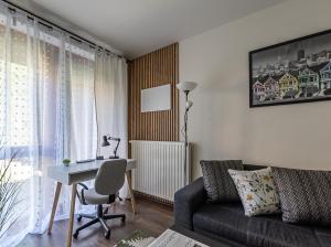 a living room with a couch and a table and a desk at Six Corners Garden Corner with Terrace and Parking in Pécs