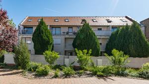 a building with a row of trees in front of it at Six Corners Garden Corner with Terrace and Parking in Pécs
