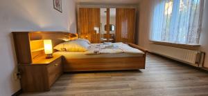 a bedroom with a wooden bed with a lamp on it at Ferienhaus Rosengarten in Blankenburg