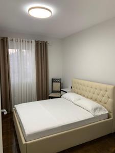 a bedroom with a large white bed and a window at Luna Mare Apartments in Orikum
