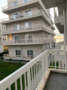a large white building with a white balcony at Luna Mare Apartments in Orikum