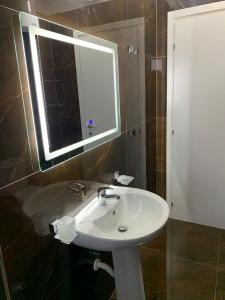 a bathroom with a white sink and a mirror at Luna Mare Apartments in Orikum +15 photos