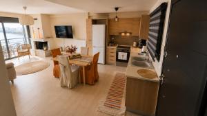 a kitchen and living room with a table and a dining room at Alia Beachfront Penthouse with Sea View in Lefkandi Chalkidas