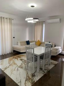 a living room with a table and chairs and a couch at Luna Mare Apartments in Orikum
