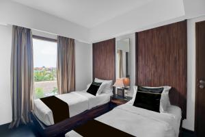 a hotel room with two beds and a window at Palette Hotel Seminyak in Seminyak +49 photos