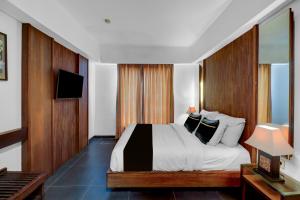 a hotel room with a bed and a television at Palette Hotel Seminyak in Seminyak