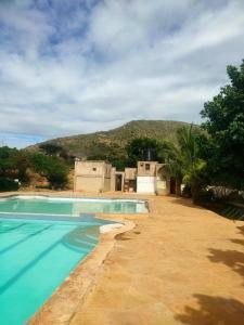 a swimming pool with a mountain in the background at Sere n' Lukundo Park & Camping Services in Voi