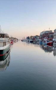 a group of boats docked in a river with houses at MAISON ART Appartements - Objekt 94080 in Warnemünde +102 photos