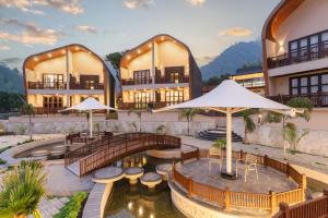 a hotel with a bridge over a pond with tables and umbrellas at Latauli Sanctuary in Upardāng Garhi