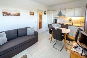 a living room with a couch and a table at Reethaus Boddenblick in Alt Reddevitz - Wohnung 4 in Mariendorf +7 photos