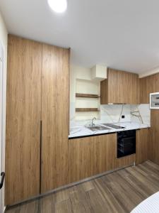 a kitchen with wooden cabinets and a sink at EDEAN Apartments 4 in Tirana +3 photos