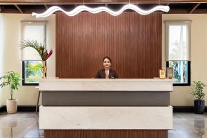 a woman is standing behind a reception desk at Latauli Sanctuary in Upardāng Garhi +99 photos