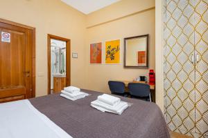 a bedroom with a bed with two towels on it at Hotel Por Santa Maria in Florence