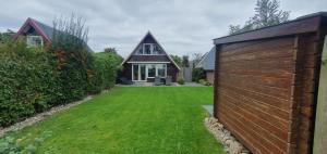 a house with a green yard with a wooden fence at De Weide Blick in Tuitjenhorn