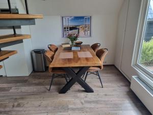 a dining room with a wooden table and chairs at De Weide Blick in Tuitjenhorn