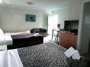 a hotel room with two beds and a flat screen tv at Motel in Nambour in Nambour