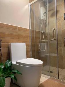 a bathroom with a toilet and a glass shower at The Pine Lush Hideout in Baguio +19 photos