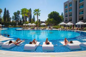 un gruppo di persone sdraiate su sedie a sdraio in piscina di Horus Paradise Resort - Ultra All Inclusive a Side
