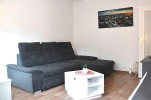 a living room with a couch and a table at GUWO Gästewohnung Goethestraße 82d in Guben