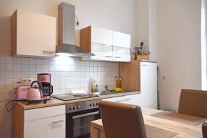 a kitchen with a sink and a stove and a table at GUWO Gästewohnung Straupitzstraße 12 in Guben