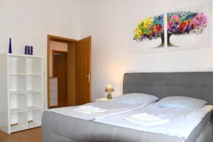 a bedroom with a bed and a painting on the wall at GUWO Gästewohnung Straupitzstraße 12 in Guben