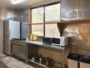 a kitchen with a counter with a microwave and a refrigerator at Hav Living in Oshima