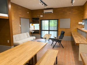 a living room with wooden tables and a couch at Hav Living in Oshima