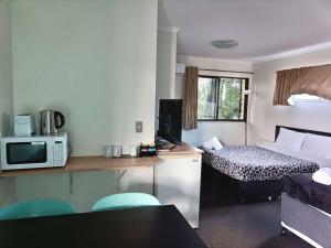 a small room with a bed and a microwave at Motel in Nambour in Nambour