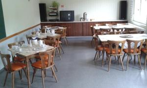 ein Esszimmer mit Tischen und Stühlen sowie eine Küche in der Unterkunft Gästehaus St. Michael in Mossautal