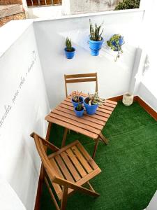 a small table and chair on a balcony with plants at Alaire Alojamiento in Algodonales