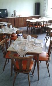 a dining room with tables and chairs with dishes on them at Gästehaus St. Michael in Mossautal