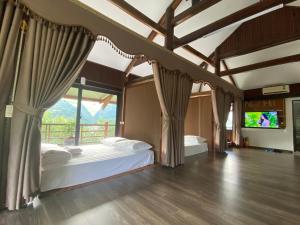 a bedroom with two beds and a large window at Nest hill retreat in Mù Cang Chải