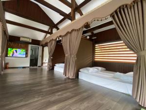 a room with two beds and a tv in it at Nest hill retreat in Mù Cang Chải
