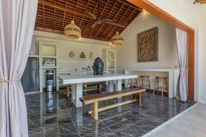 a kitchen with a table and a bench in a room at Tropical Villas Complex in Jimbaran