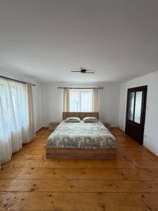 a bedroom with a bed and a wooden floor at Casa Pietrele Doamnei in Câmpulung Moldovenesc