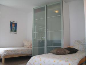 Ein Zimmer mit einer Glastrennwand, in dem ein Bett und eine Couch stehen. in der Unterkunft Haus Holste in Hambergen