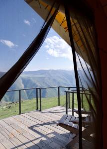 a wooden deck with a table and a bench on a balcony at Yagoda Moya in Khot