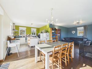 eine Küche und ein Wohnzimmer mit Tisch und Stühlen in der Unterkunft Chez Isaline Libin in Libin
