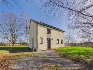 ein großes weißes Gebäude auf einem grasbewachsenen Feld in der Unterkunft Chez Isaline Libin in Libin