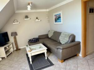 a living room with a couch and a tv at Ferienwohnung Petersen in Nordstrand